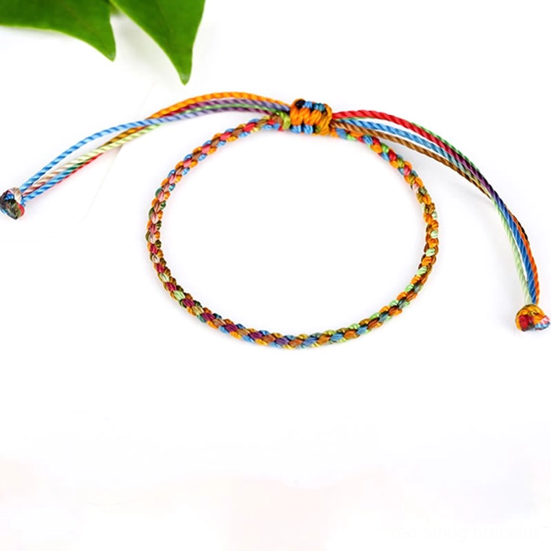 Multicolored red string bracelet packaged for gifting with care instructions and wish-setting guide