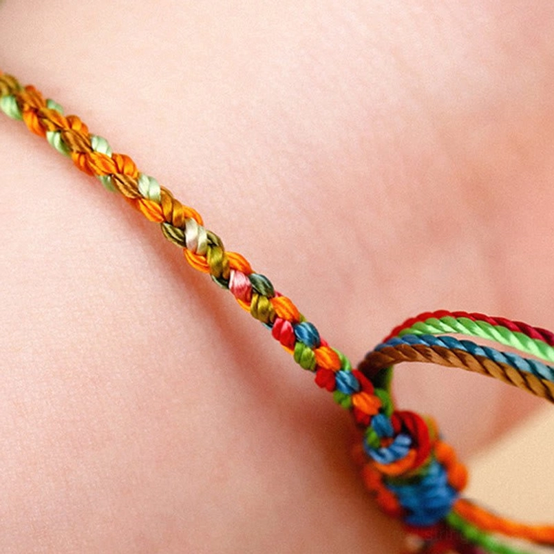 Rainbow twisted braid bracelet worn on skin showing adjustable knot structure and comfortable fit