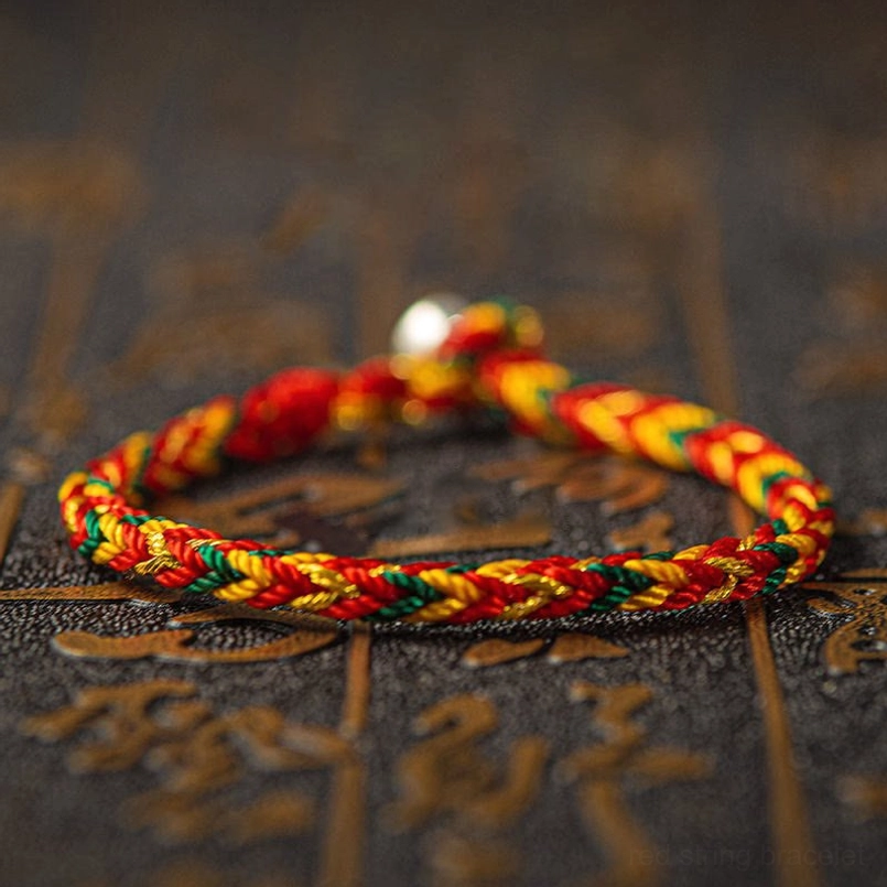 Front view of handmade multicolored woven bracelet with full rope body and silver decorative bead