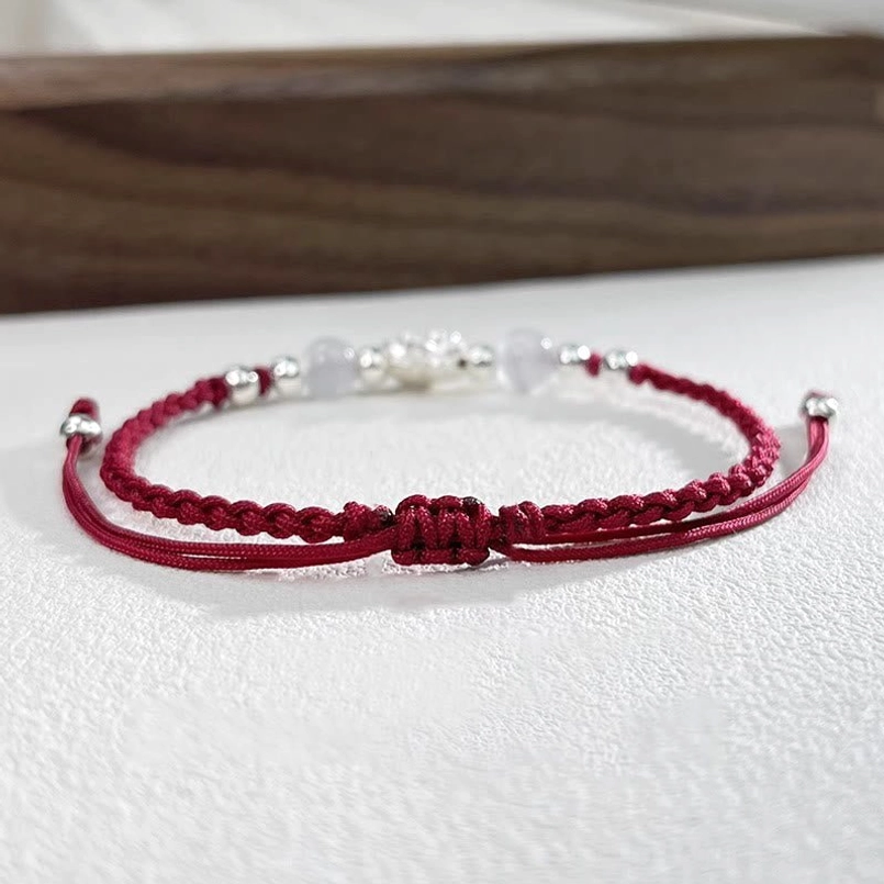 cat's eye bead close up on sterling silver lotus red string bracelet