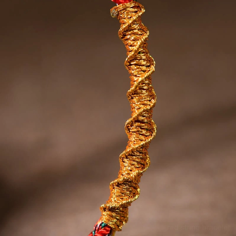 Macro shot of twisted gold red braided red string bracelet texture