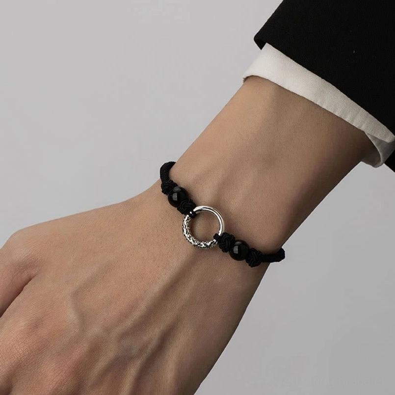 Wrist view of adjustable black onyx peace buckle bracelet with white shirt cuff