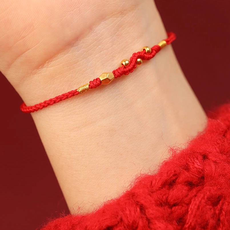 Delicate 999 gold snake red string bracelet close up wearing on wrist