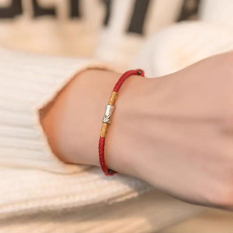 Minimal red braided bracelet side closeup view with metal charm