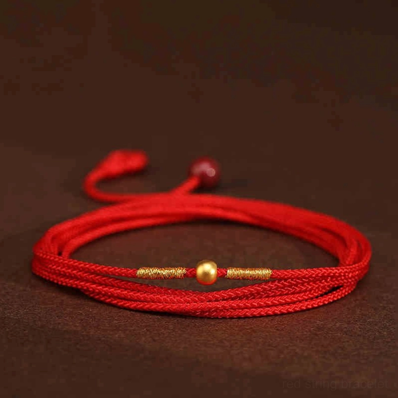 Minimalist red string belly chain flat lay with smooth cord and two gold round beads detail shot