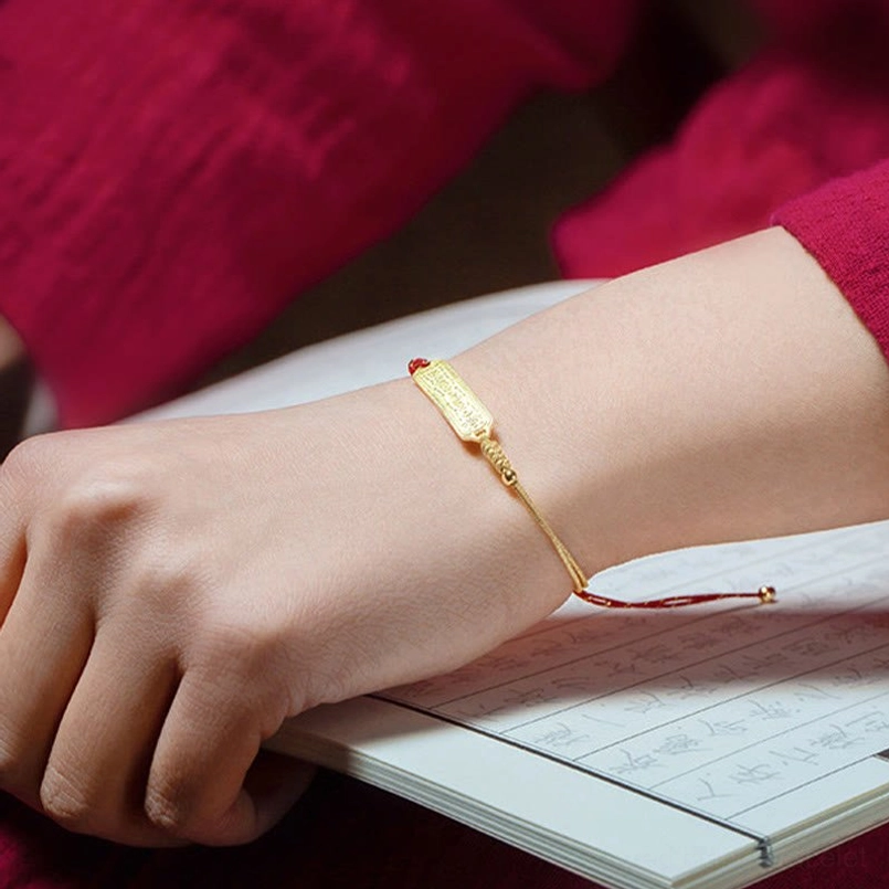 Minimalist red gold bracelet worn on right wrist on handwritten book