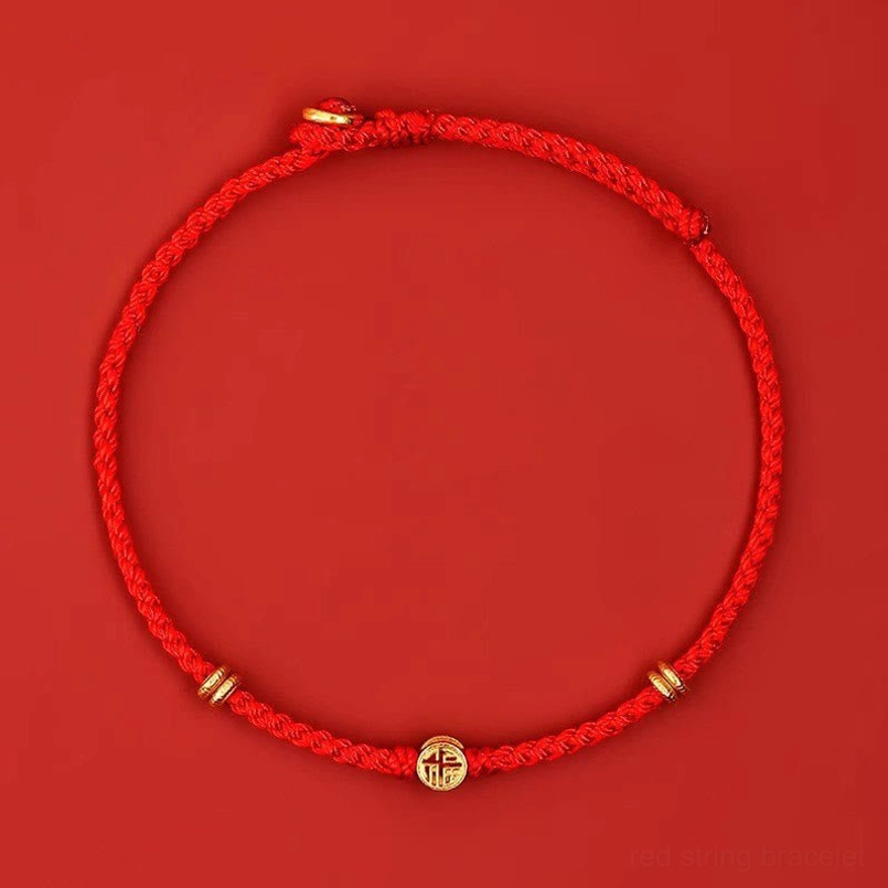 Minimalist woven red string bracelet with silver Fu charm flat lay