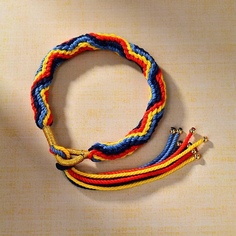 Round braided Tibetan red string bracelet full view on table