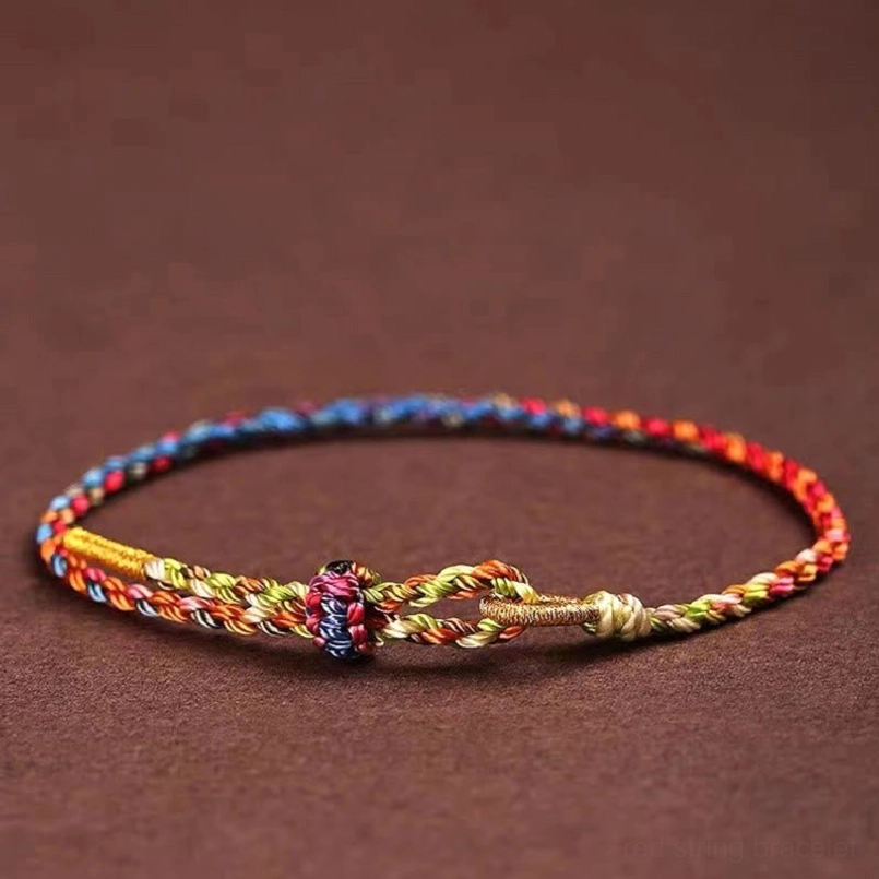 Lucky braided bracelet with red blue yellow twisted cord and central woven knot detail