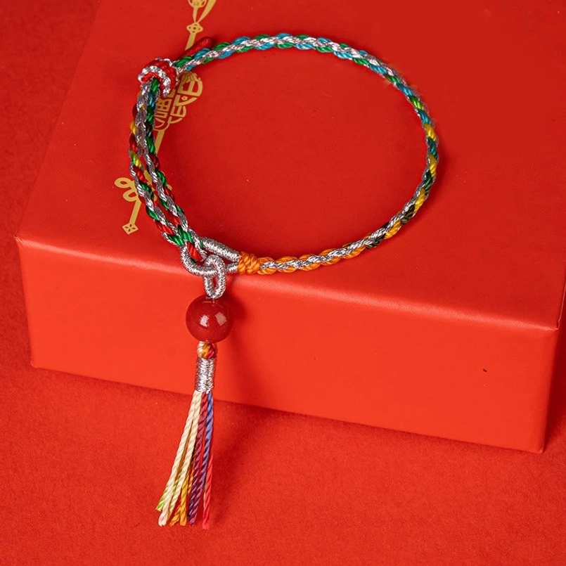 Top view multicolor cinnabar bead braided bracelet on red hardcover box