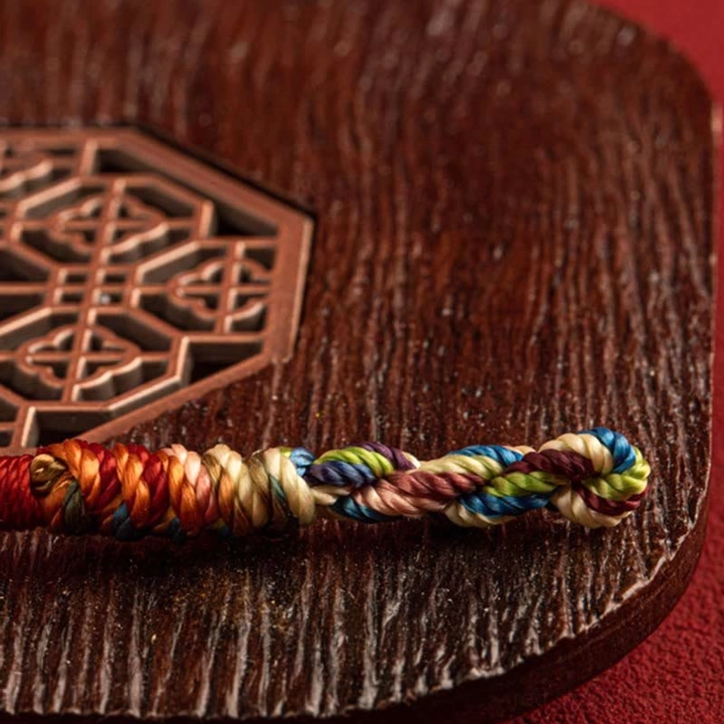 Close-up detail of twisted multicolor threads and King Kong knot weave in handmade bracelet