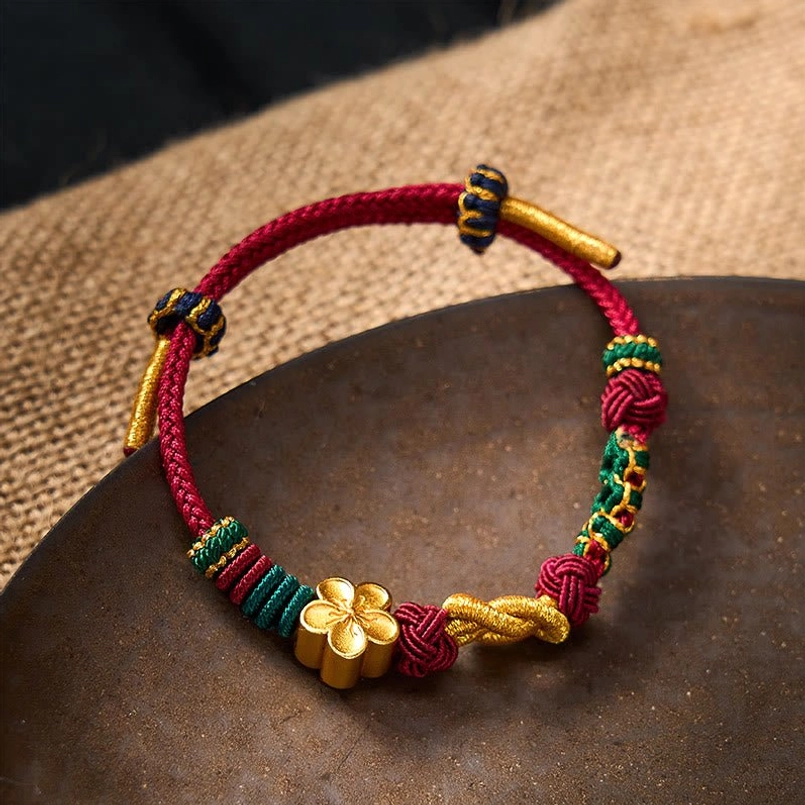 Hand-woven couple bracelet with color-block knots and metal tube fasteners on natural background