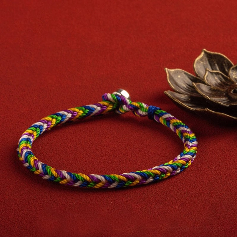 Multicolor braided lucky bracelet with full loop and metal clasp, decorative red background