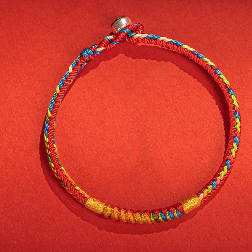 Close up detailed braided pattern of multicolor red string bracelet on red background