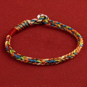 Multicolor red string bracelet with King Kong knot and silver buckle closure on red background