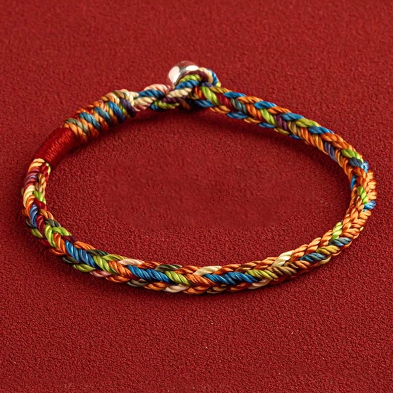 Multicolor red string bracelet with King Kong knot and silver buckle closure on red background