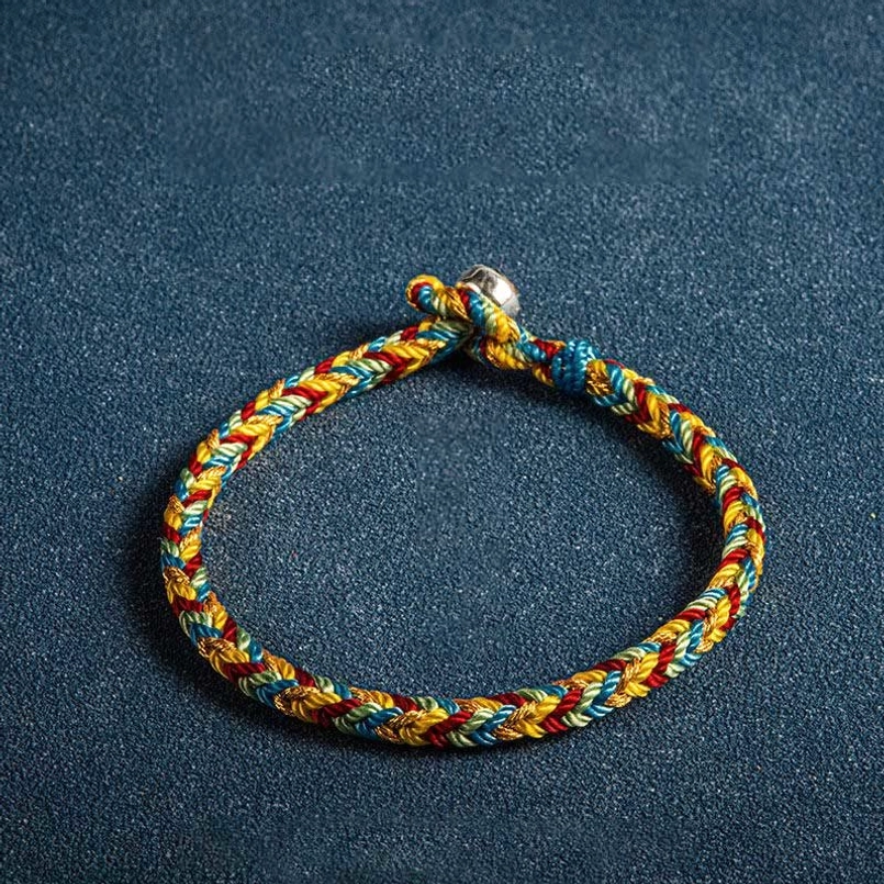 Multicolor red string bracelet featuring silver magnetic clasp and King Kong knot on solid deep blue background