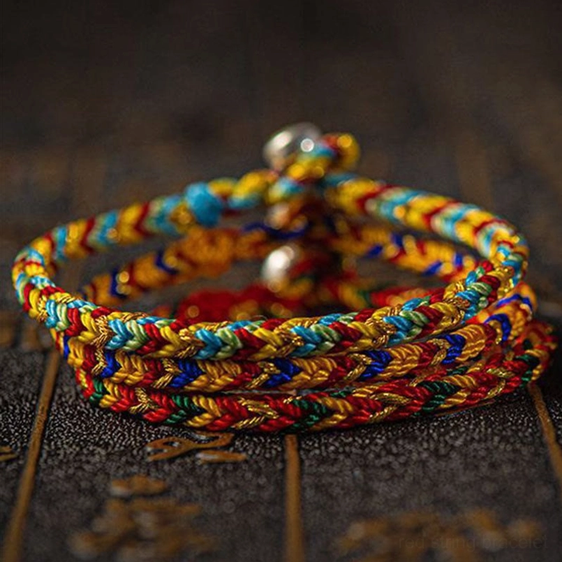Stacked multicolored woven lucky bracelets with vibrant rainbow colors and silver beads