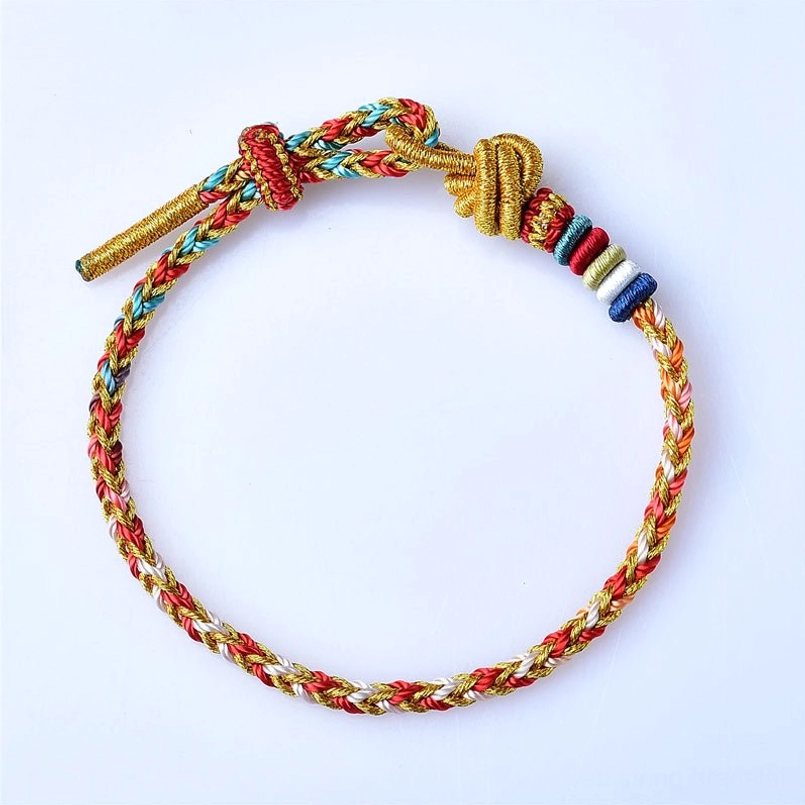 Top down view of multicolor red string bracelet with red blue gold woven threads