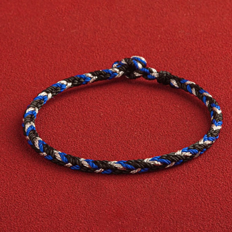 Multicolored red string bracelet with tri-color weave and king kong knot closure, top-down view