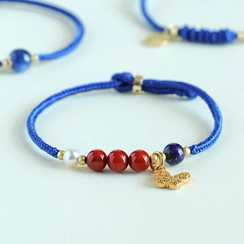 Set of multiple blue cord lucky bracelets with copper butterfly pendants on gradient blue background