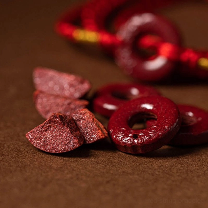 Macro close-up of raw cinnabar stones and carved cinnabar pendants used in waist chain