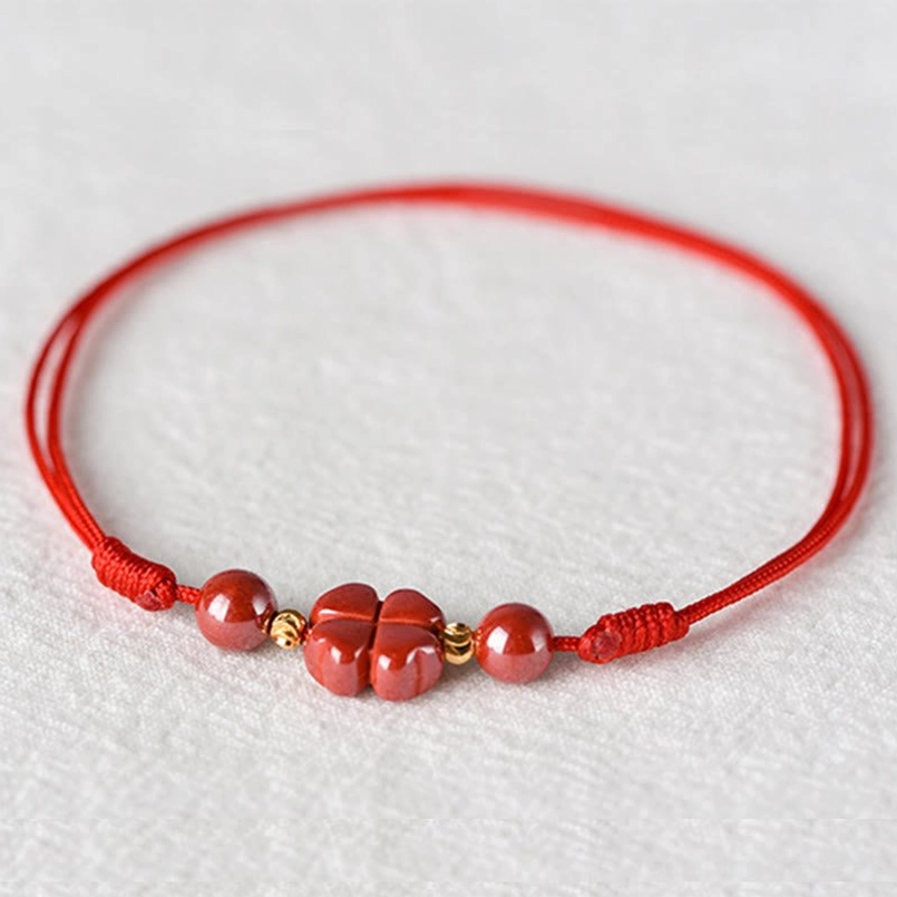 Premium natural cinnabar stone beads with four-leaf clover charm detail shot