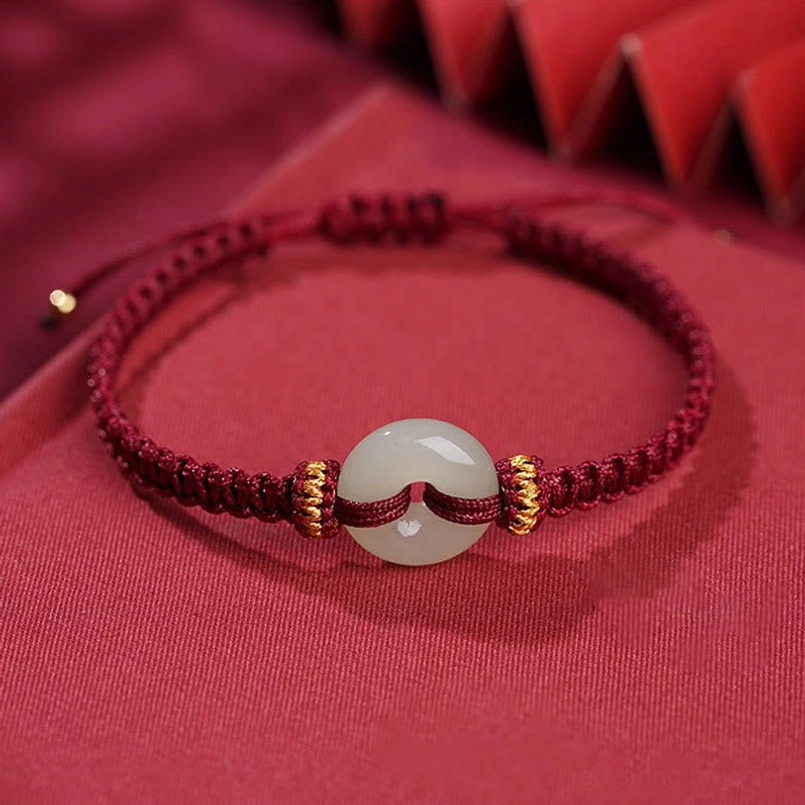 Jade peace buckle braided bracelet flat lay on red background
