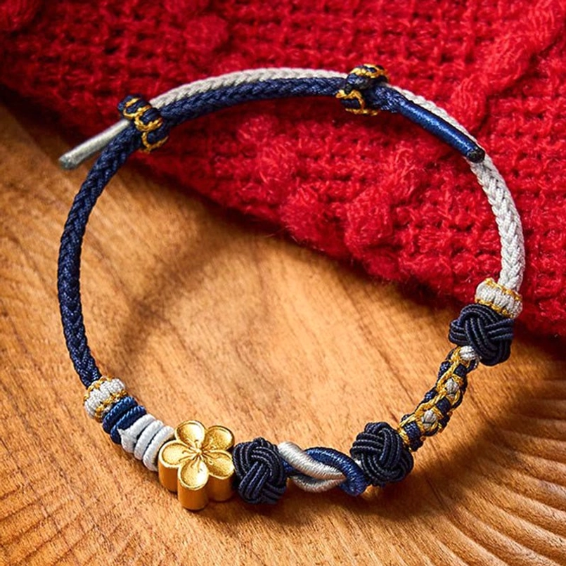 Navy blue two-tone braided couple bracelet with gold four-leaf charm and woven knots