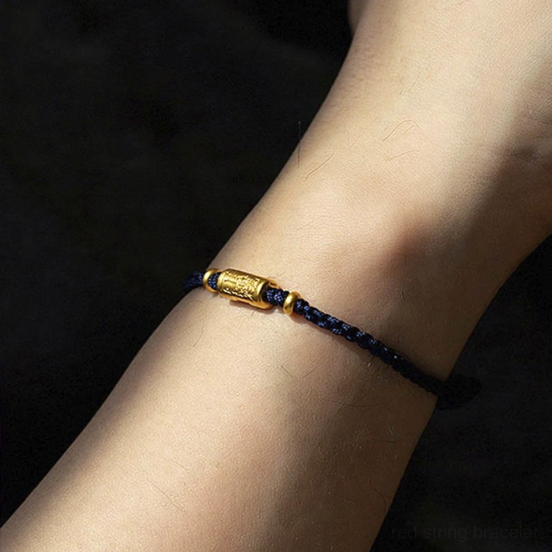 Navy blue braided lucky bracelet with gold charm on wrist - minimalist style