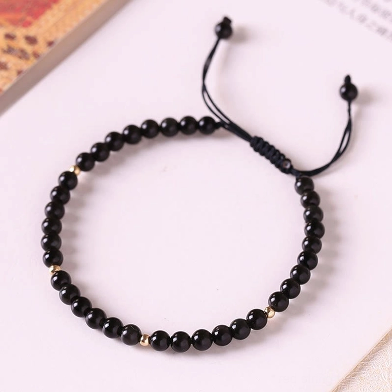 Minimalist black obsidian beaded string bracelet with dual sliding knot closure, top-down view