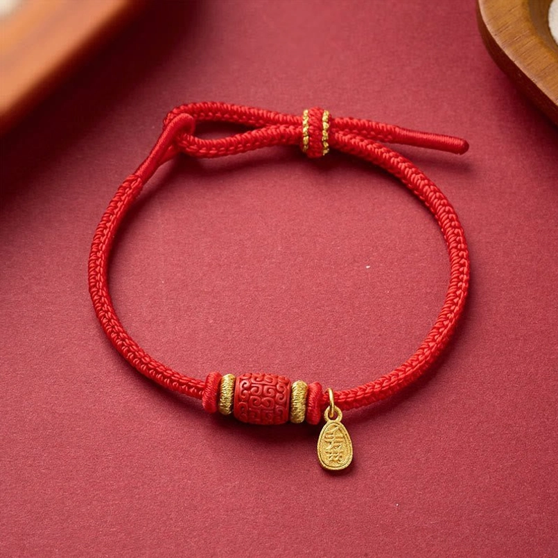 Braided red string luck bracelet with carved copper bead and gold accents