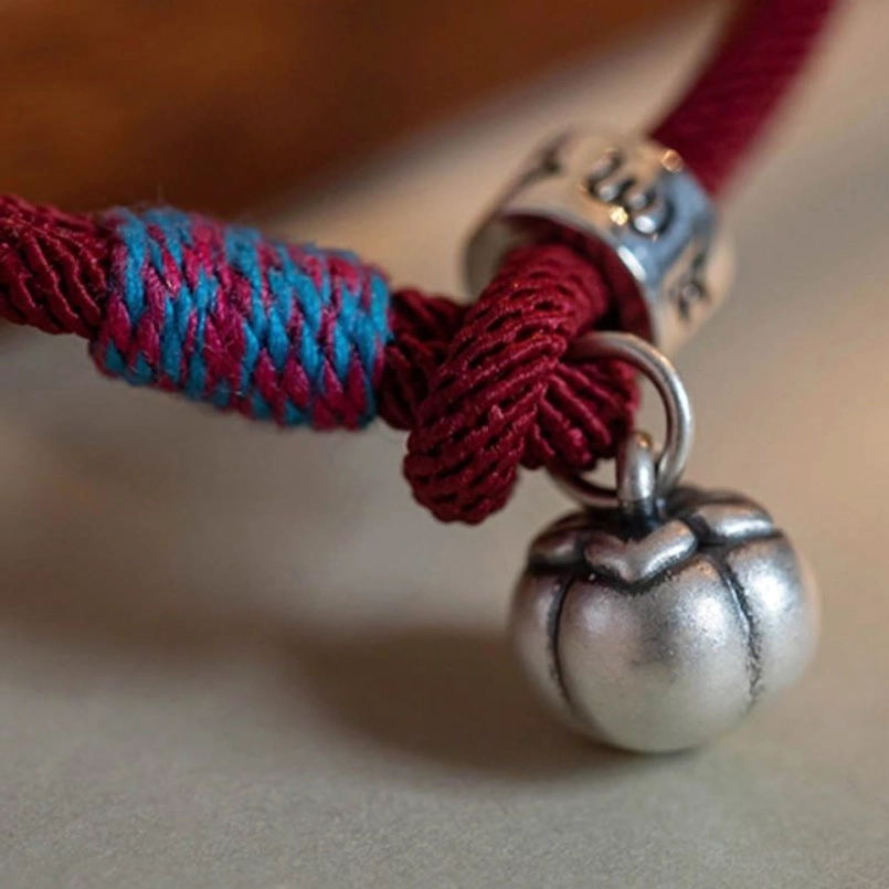 Handmade Tibetan bracelet charm components with colorful woven accent on wooden surface