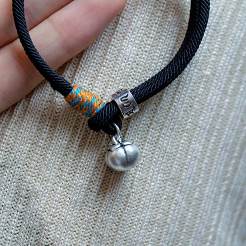 Handcrafted Tibetan bracelet silver charm and woven knot close-up on knitted background