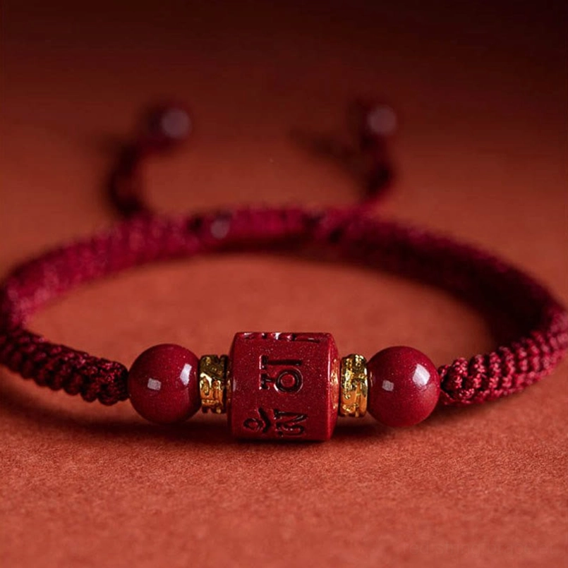Close-up detail of carved cinnabar bead with gold spacers om mani padme hum bracelet