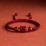Om Mani Padme Hum cinnabar blessing bracelet with wine red braided cord front view