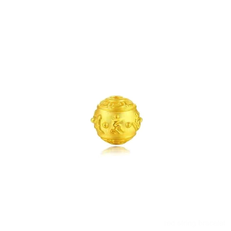 Engraved gold spherical Om Mani Padme Hum mantra bead detail on white background