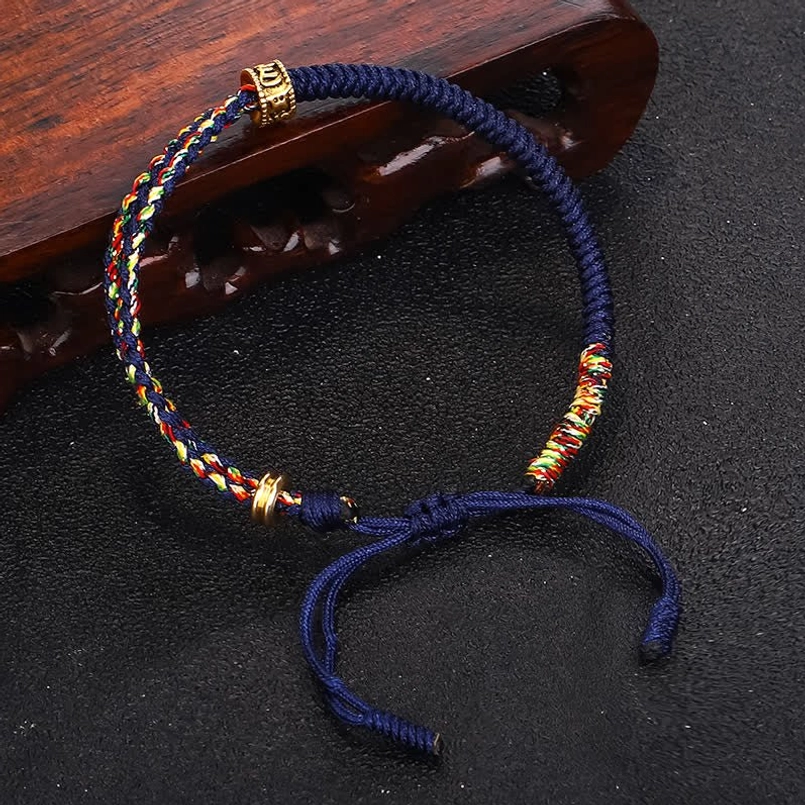 Om Mani Padme Hum spiritual bracelet with mantra charm and colorful threads - detail close-up