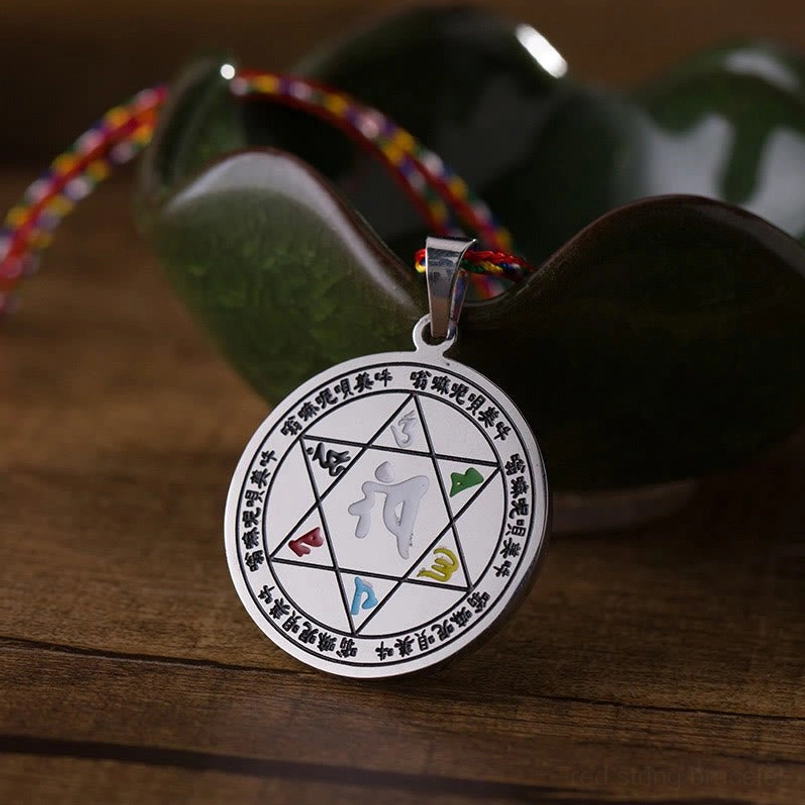 Round silver Buddhist mantra pendant with six-word inscription, side angle view