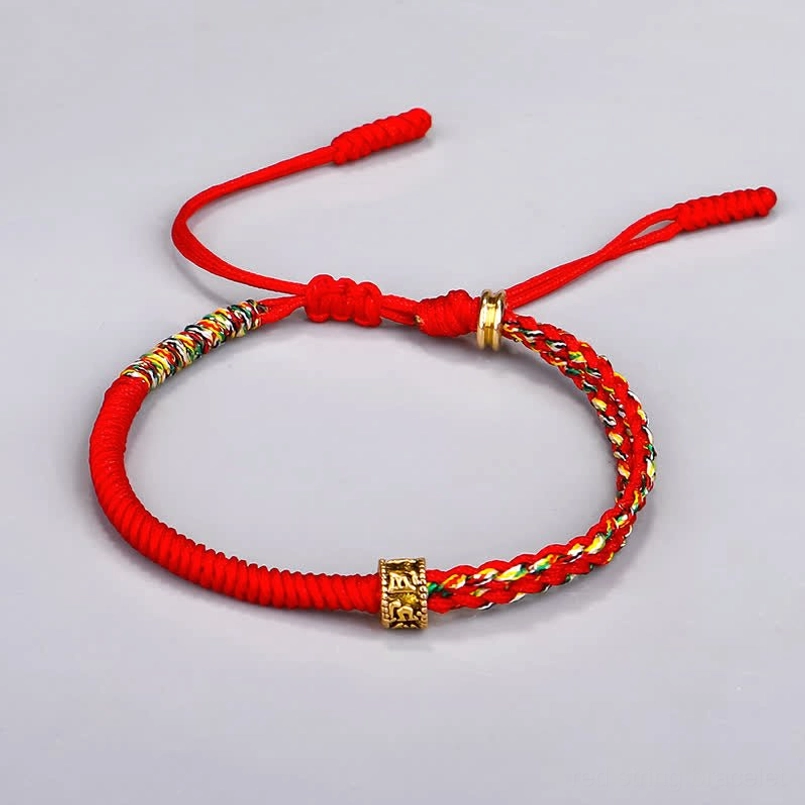 Om Mani Padme Hum red string bracelet with woven colorful accents and gold beads - flat lay detail