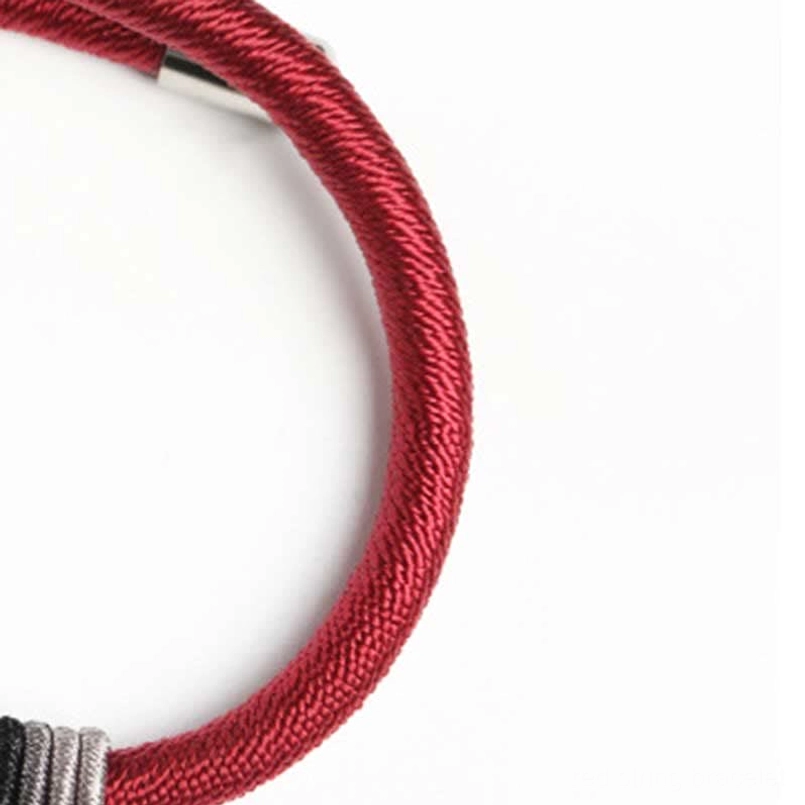 Red braided cord with 925 silver Om Mani Padme Hum charm, close-up side view on white background