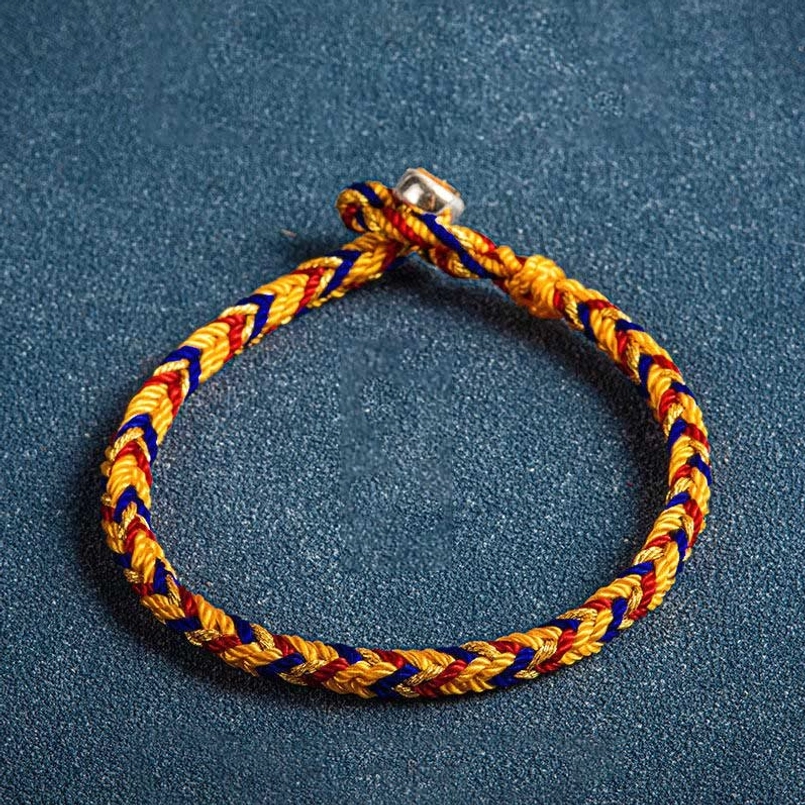 Multicolor orange dark blue red string bracelet with silver charm and protective King Kong knot on dark background