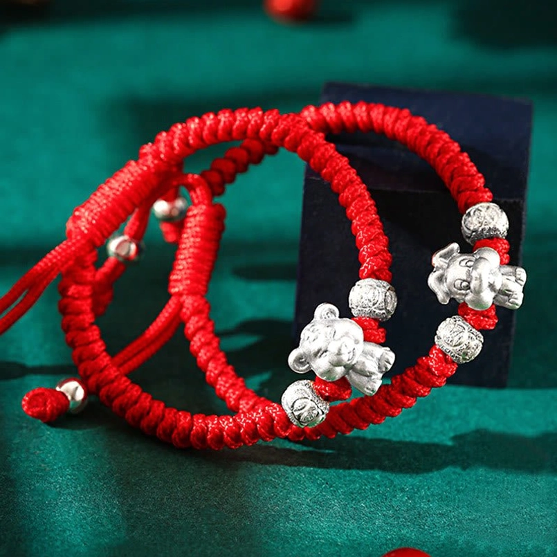 Dual zodiac 999 sterling silver red woven rope bracelets oblique view with cute animal charms