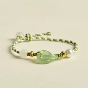Green and white braided peace buckle bracelet overhead view with jade charm and gold accents