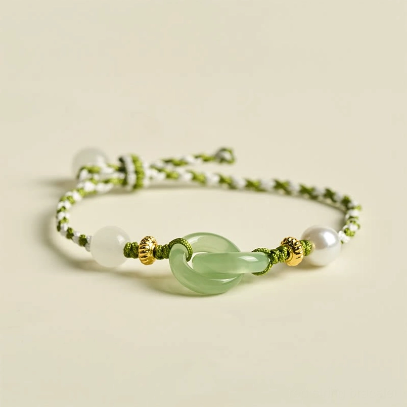 Green and white braided peace buckle bracelet overhead view with jade charm and gold accents