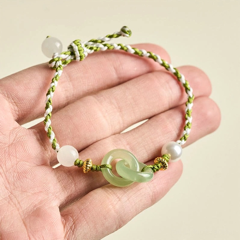 Peace buckle jade bracelet held in hand close-up detail braid pearl gold accents