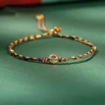 Handmade multicolor peace buckle bracelet with golden charm on dark background
