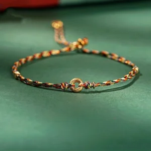 Handmade multicolor peace buckle bracelet with golden charm on dark background