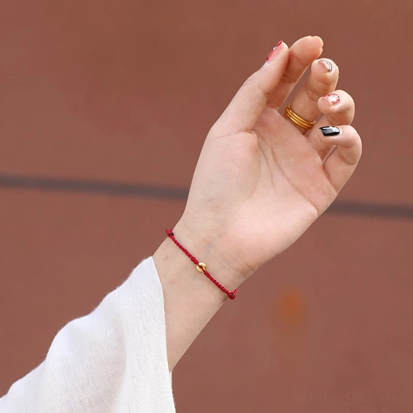 worn red string protection bracelet on wrist showing minimalist design and fit