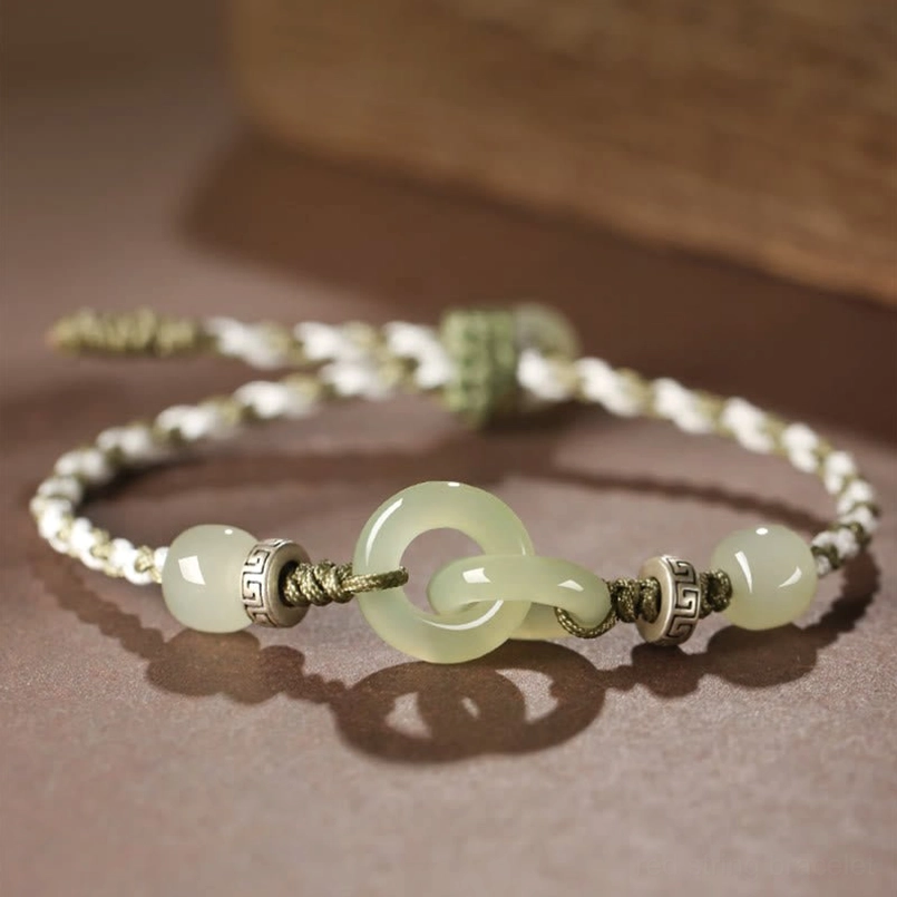 Close-up detail of interlocking double peace buckles and round jade spacer beads with vintage metal accents